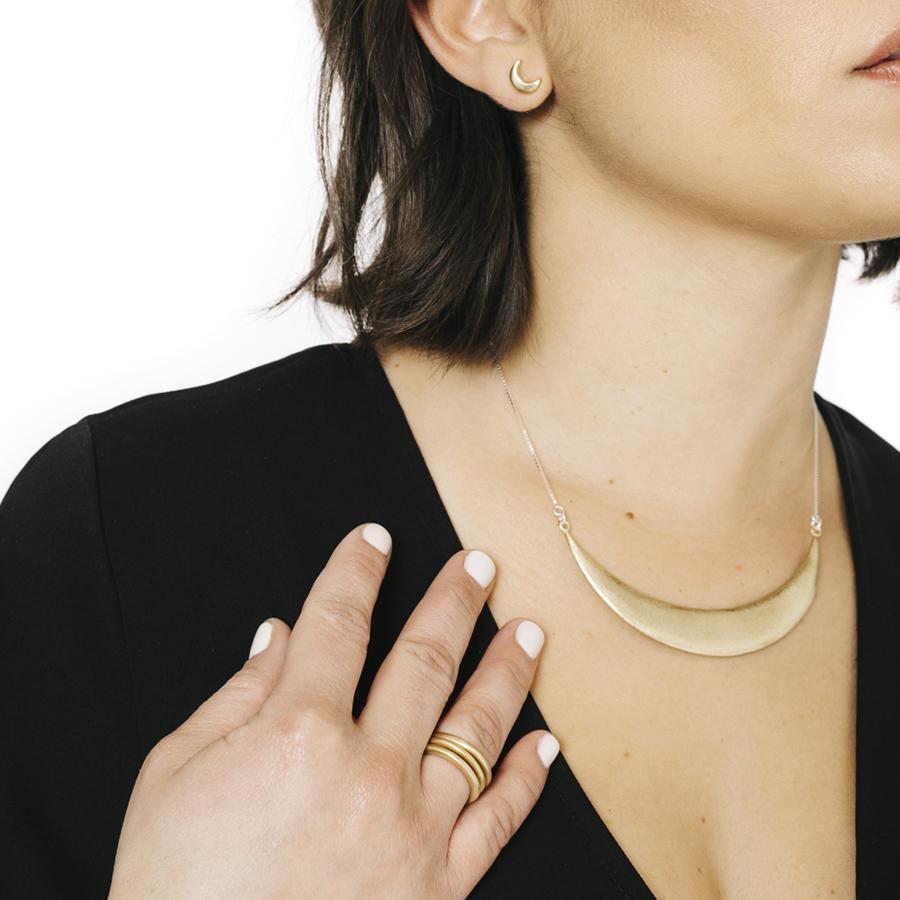Woman wearing minimalist crescent moon ring in bronze