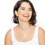 Woman wearing minimalist kite necklace and earrings in yellow bronze