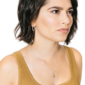 Woman wearing minimalist tiny gold star necklace