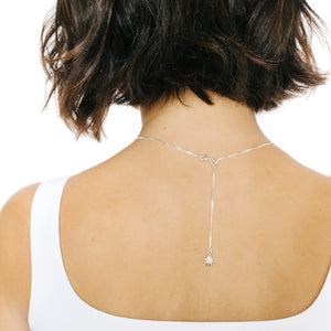 Woman wearing silver necklace chain with small star charm