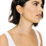 Woman wearing mnimalist kite shaped earrings in sterling silver