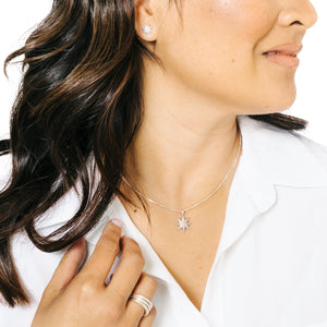 Woman wearing minimalist silver star stud earrings