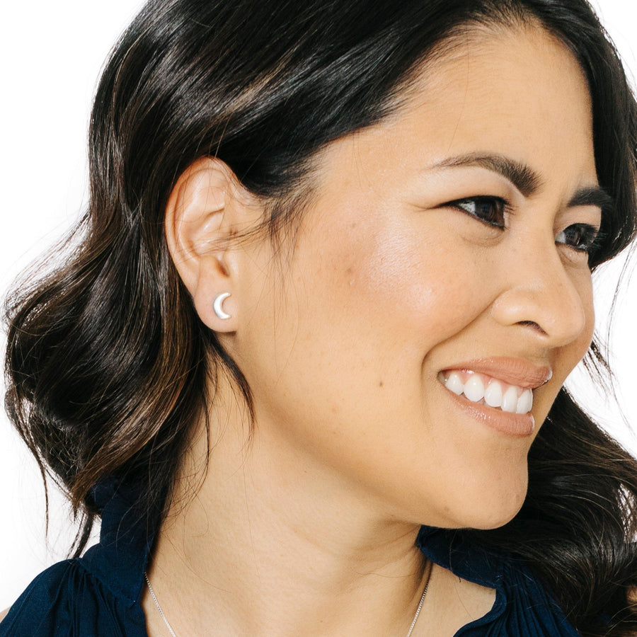 Woman wearing minimalist crescent moon earrings in silver