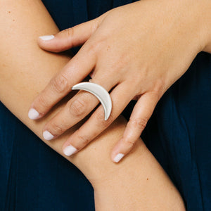 Woman wearing statement crescent moon ring in silver