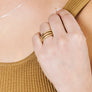 Woman wearing set of minimalist stacking rings in gold
